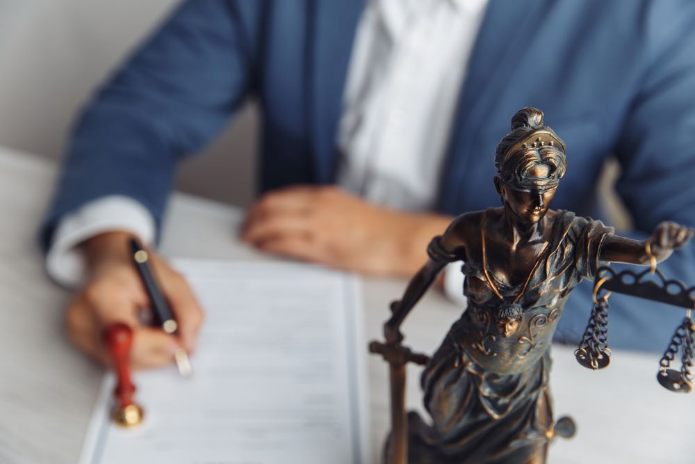 Benefits of Hiring a Lawyer for HOA Disputes Image of a lawyer signing documents at an office, featuring 411 Real Estate Law and highlighting 'Benefits of Hiring a Lawyer for HOA Disputes,' ensuring it aligns with the page's context.