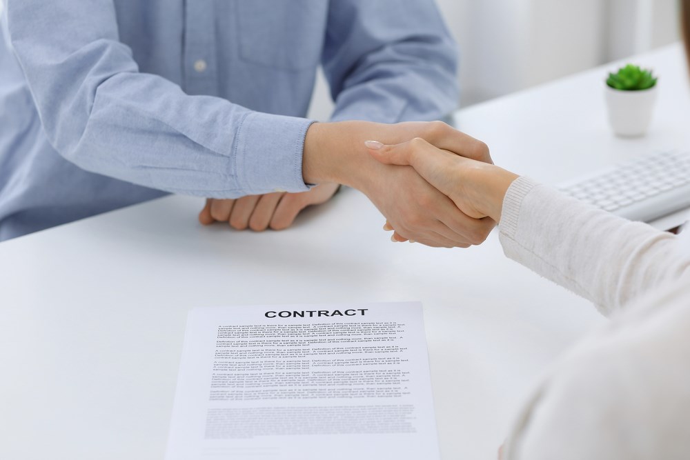 Image of business people shaking hands at a meeting or negotiation after signing a contract, featuring 411 Real Estate Law and highlighting Negotiating Fair Compensation, ensuring it aligns with the page's context on achieving equitable agreements in real estate transactions.