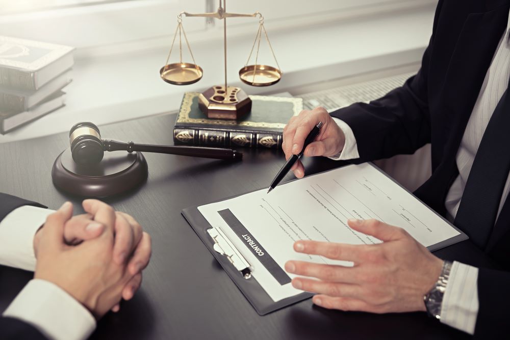 The Attorney’s Role in Closing Image of a male lawyer working with contract papers, featuring 411 Real Estate Law and highlighting 'The Attorney’s Role in Closing,' ensuring it aligns with the page's context.